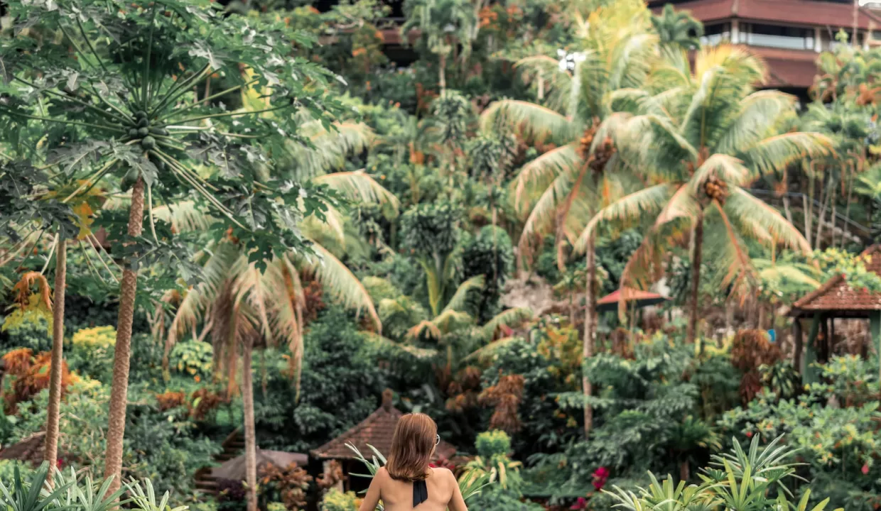 woman in infinity pool with overlooking view of trees